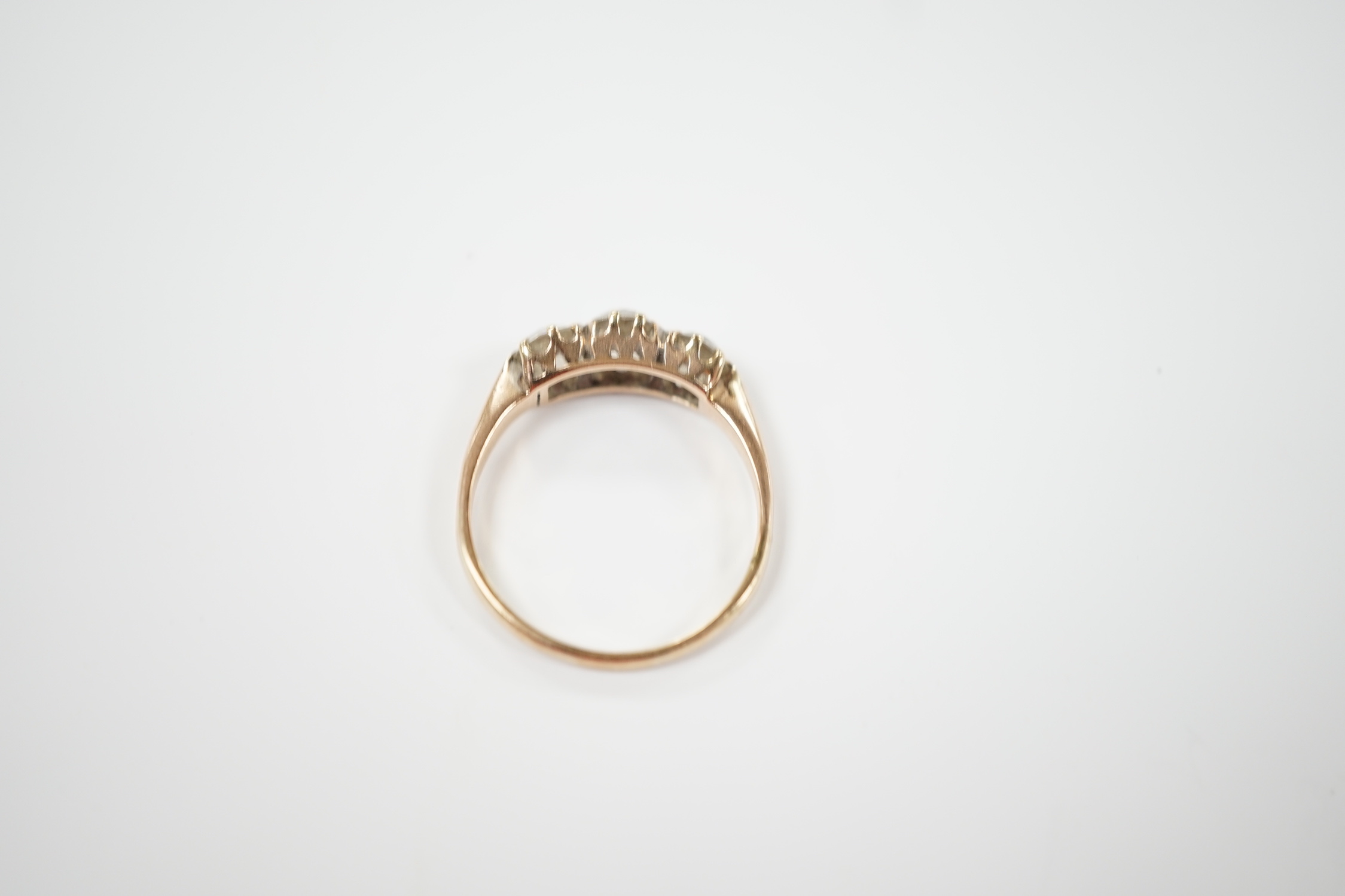 A yellow metal and three stone diamond set ring, size P, gross weight 2.6 grams.